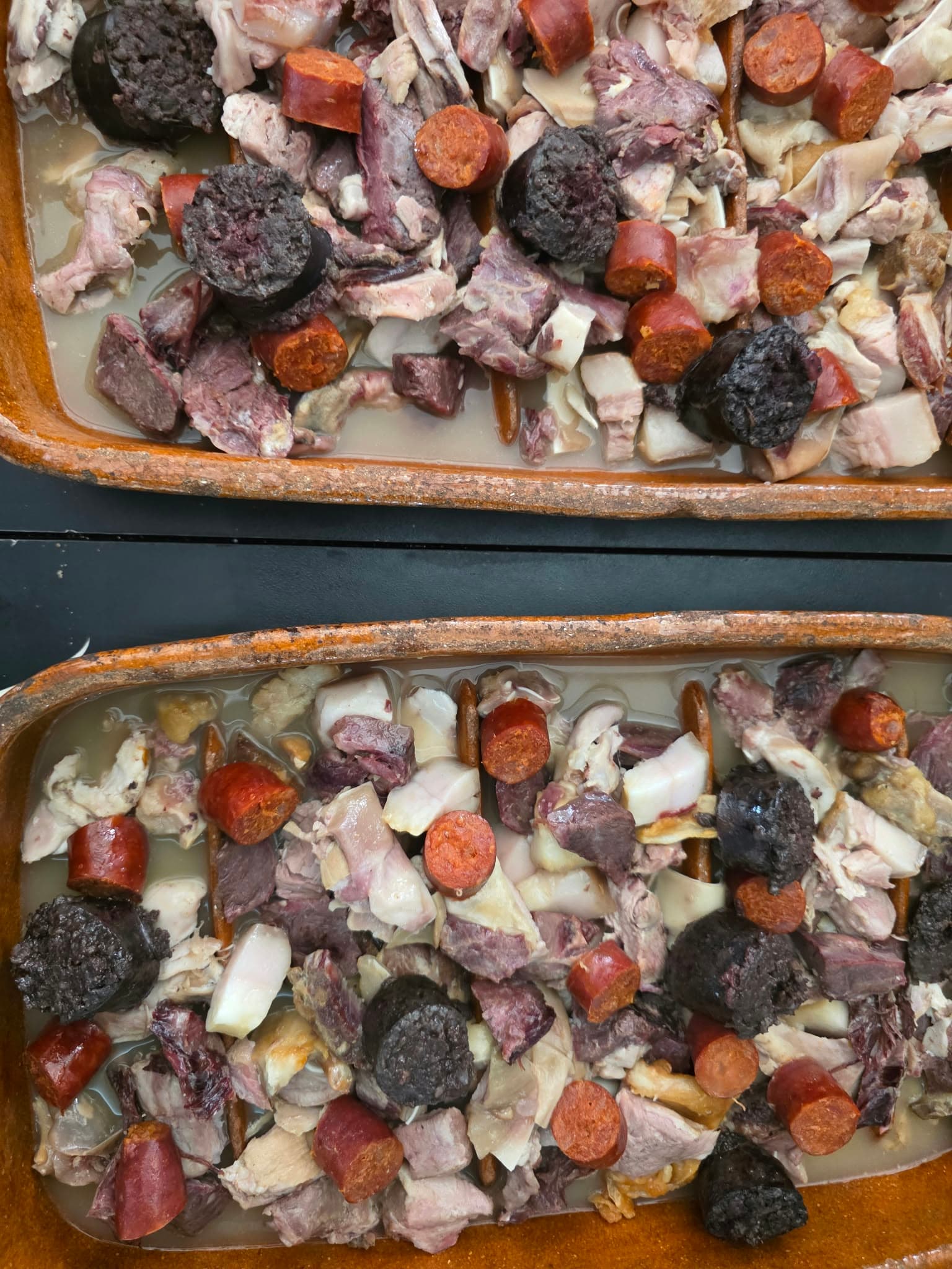 Carnes, garbanzos y verdura del cocido servidos en la mesa